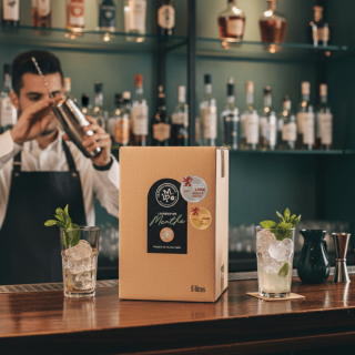 Cubi de 5 litres de Liqueur de Menthe 'La Petite Merveille' sur un comptoir de bar, entouré de cocktails frais.