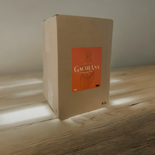 BIB 5L Gachiana, spiritueux à la gentiane, posé sur une table en bois avec un jeu de lumière naturelle.