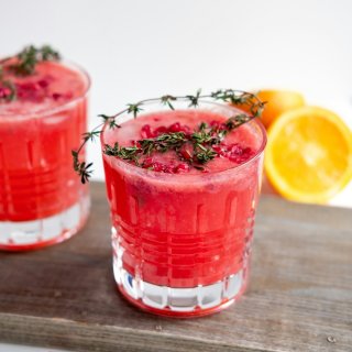 Deux verres de cocktail Daïquiri Fraise servis sur glace avec herbes fraîches.
