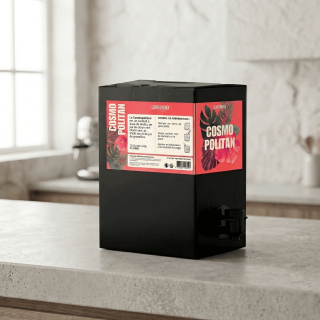 Fontaine noire de cocktail Cosmopolitan posée sur un plan de travail de cuisine lumineux