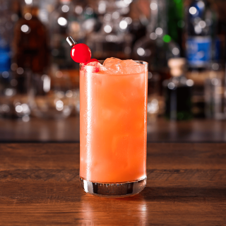 Verre de cocktail Sex on the Beach très frais, servi sur glace avec une cerise décorative