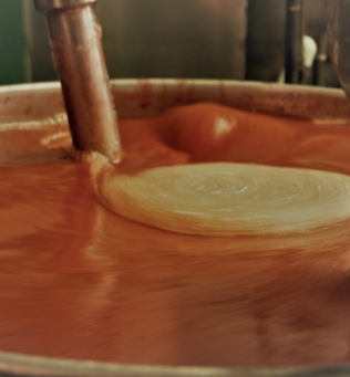 Préparation de fruits bio visqueux (confiture ou crème de marron) en cours de cuisson artisanale.