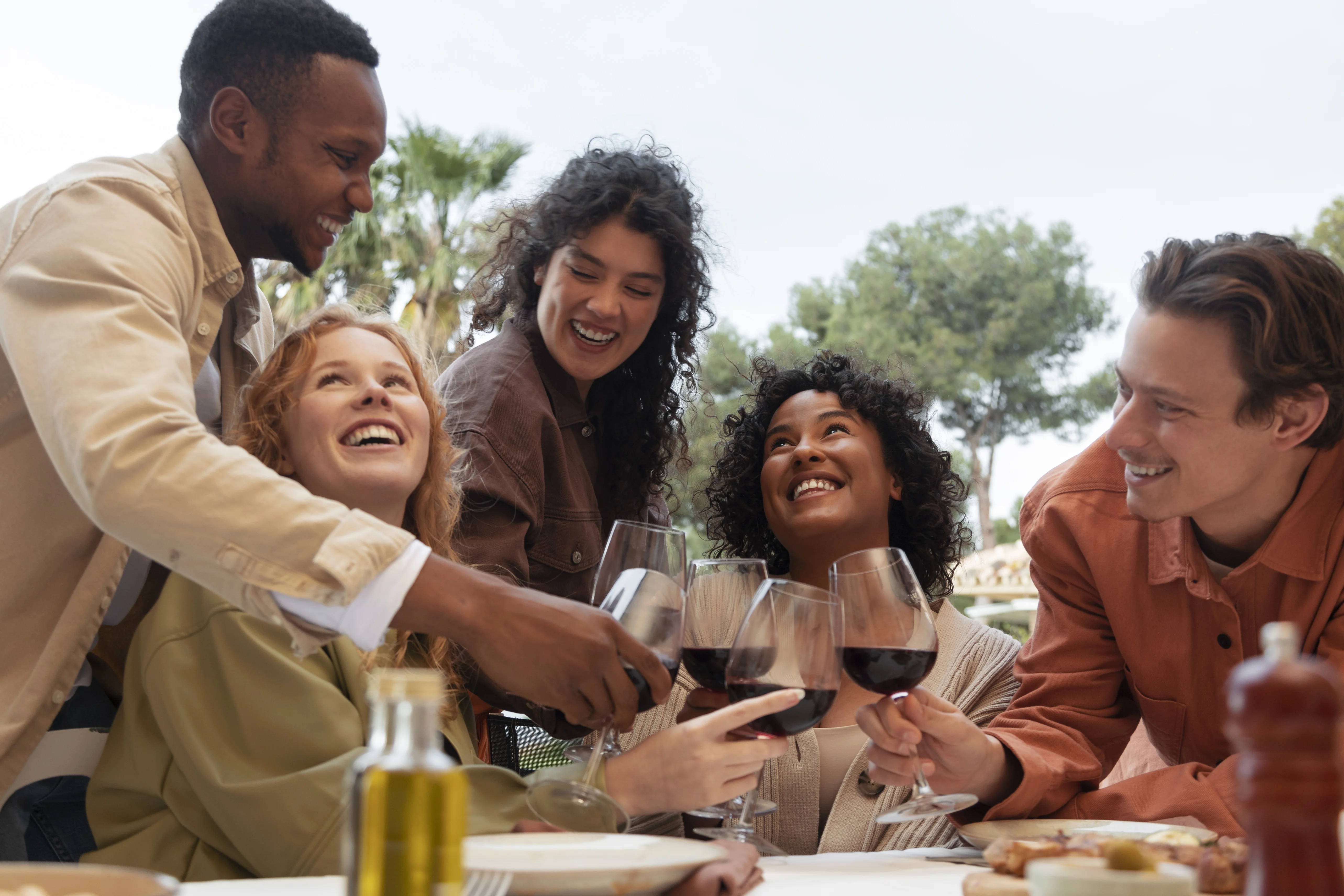 Dégustation de vin rouge entre amis lors d'un repas convivial en extérieur